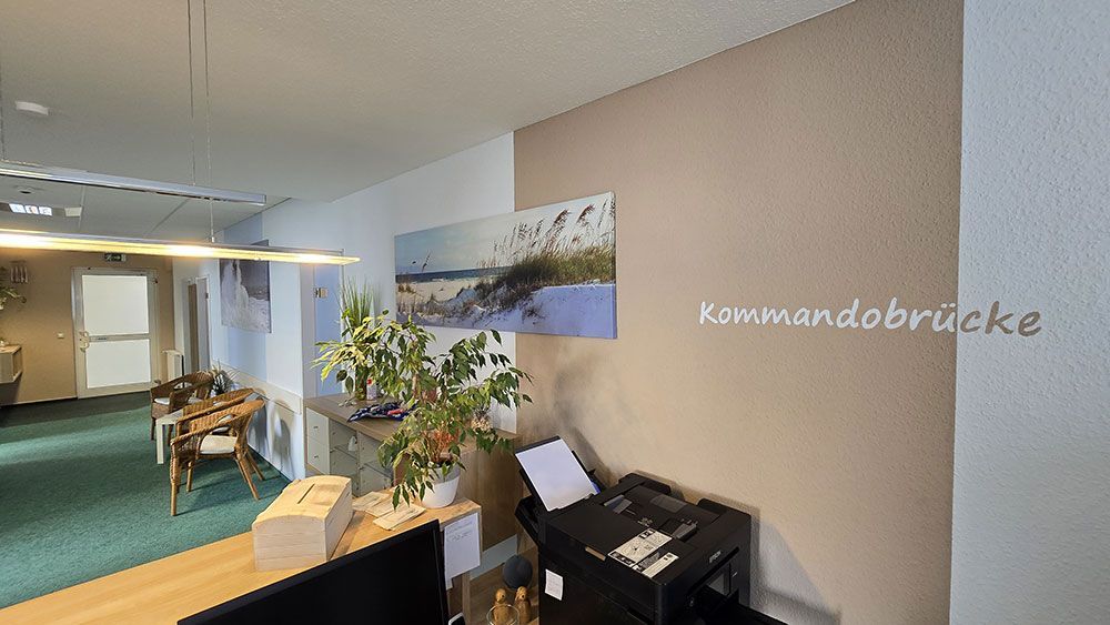 Ein Raum mit einem Drucker und einem Gemälde an der Wand.