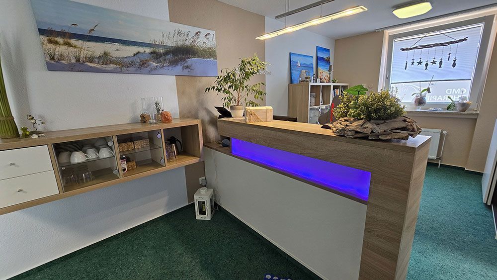 Eine Rezeption mit blauem Licht in einem Raum mit grünem Teppich.