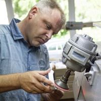 Ein Mann arbeitet in einer Fabrik an einer Maschine.