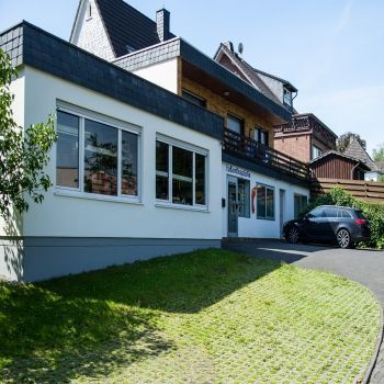 Ein weißes Haus mit einem davor geparkten Auto