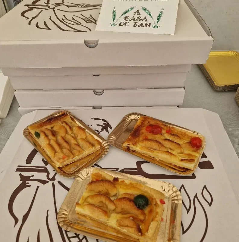 Pasteles de manzana en bandejas, cajas de panadería apiladas con el logo 