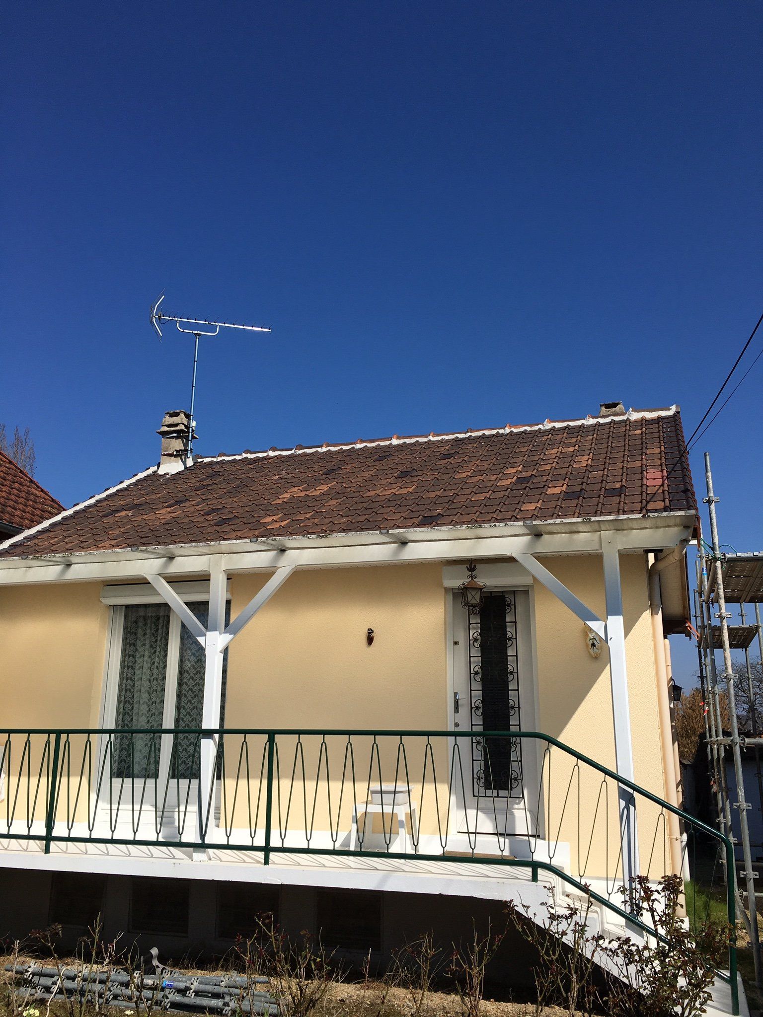Maison traditionnelle avec toit en tuile rouge et antenne