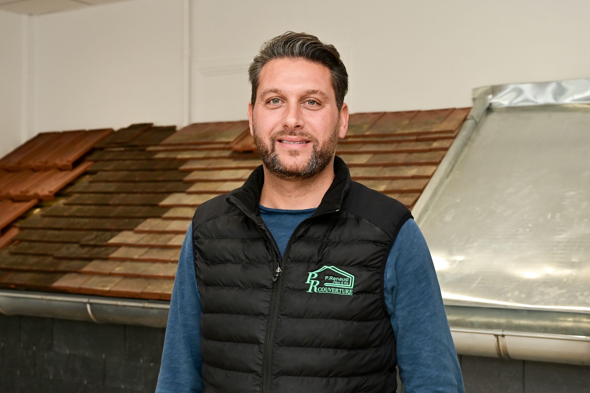 Artisan posant dans le showroom de PR Couverture
