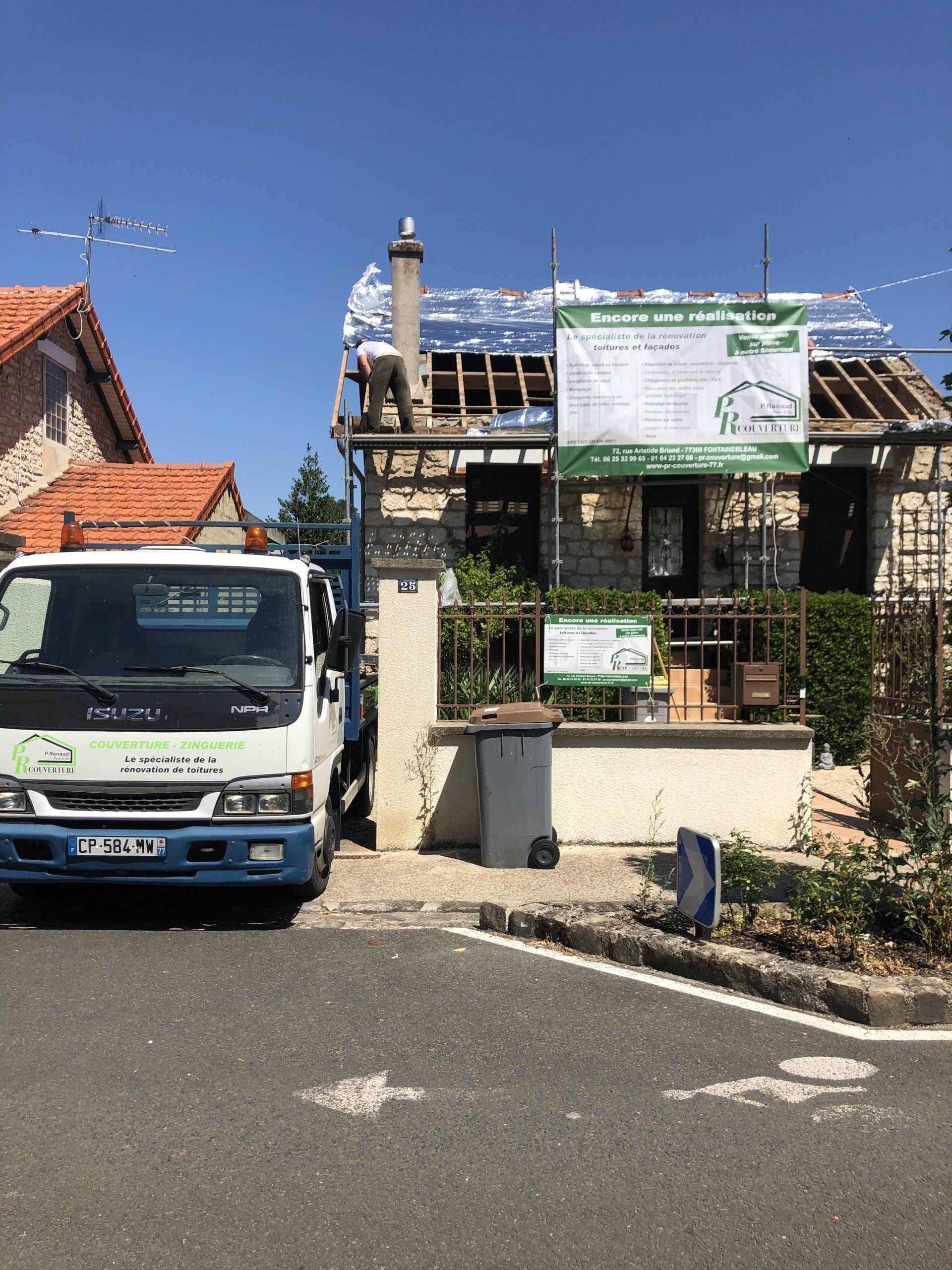 Maison avec toit en rénovation, présence d'un échafaudage de panneau d'informations sur PR Couverture et camion utilitaire
