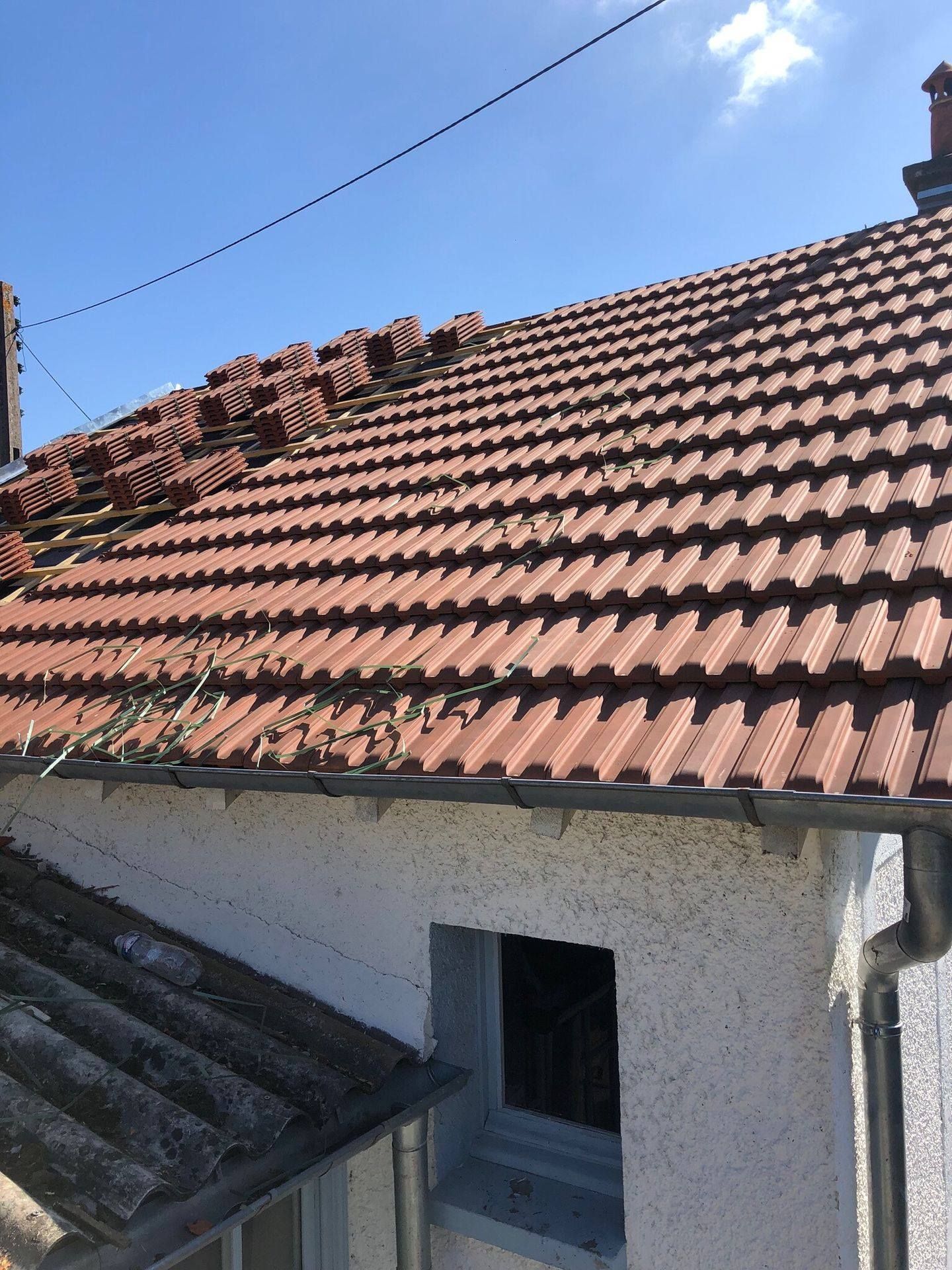 Toit en tuiles rouges récemment posées sur une charpente rénovée