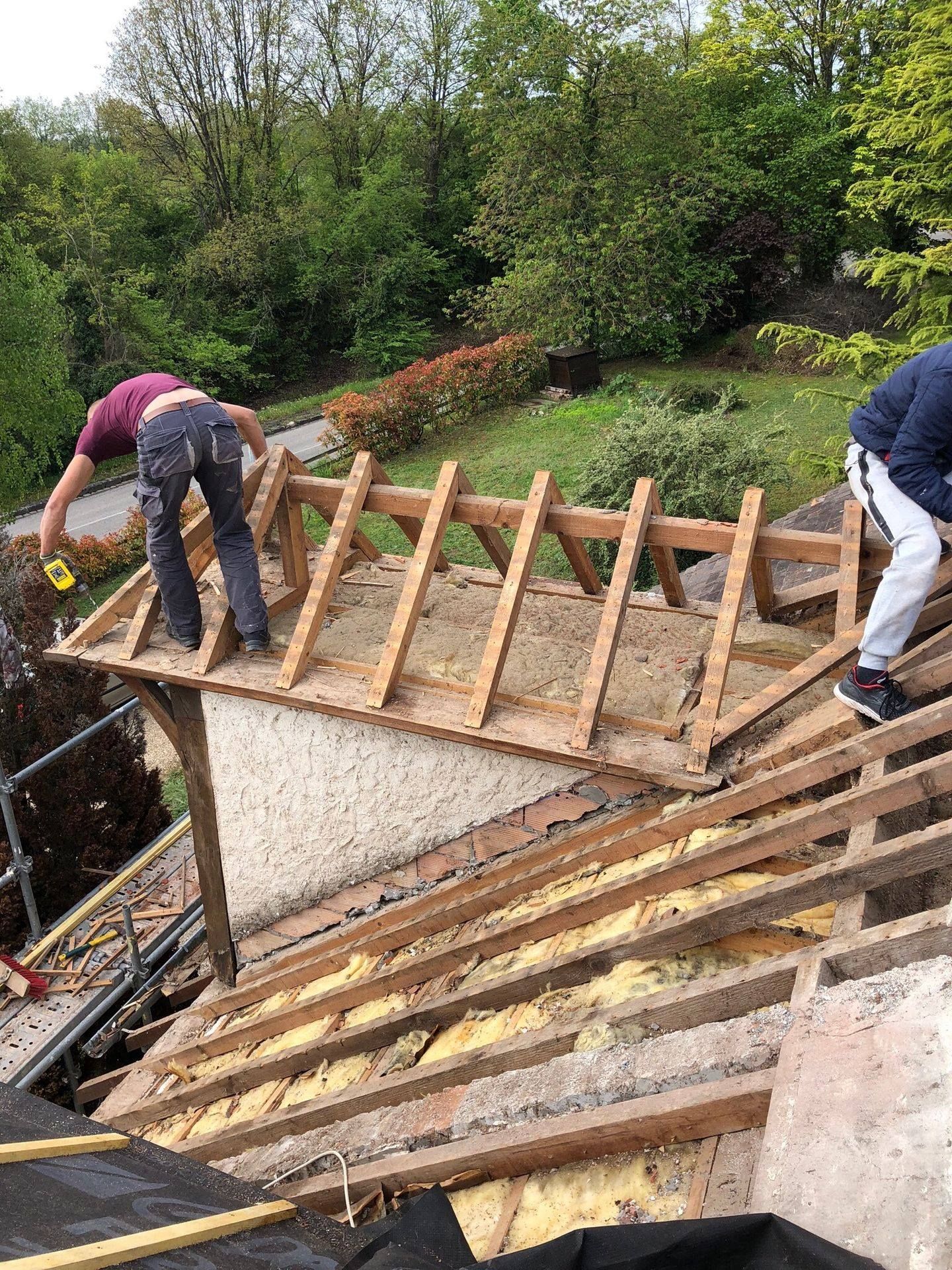 Artisans travaillant sur une charpente en bois d'une petite extension de toit