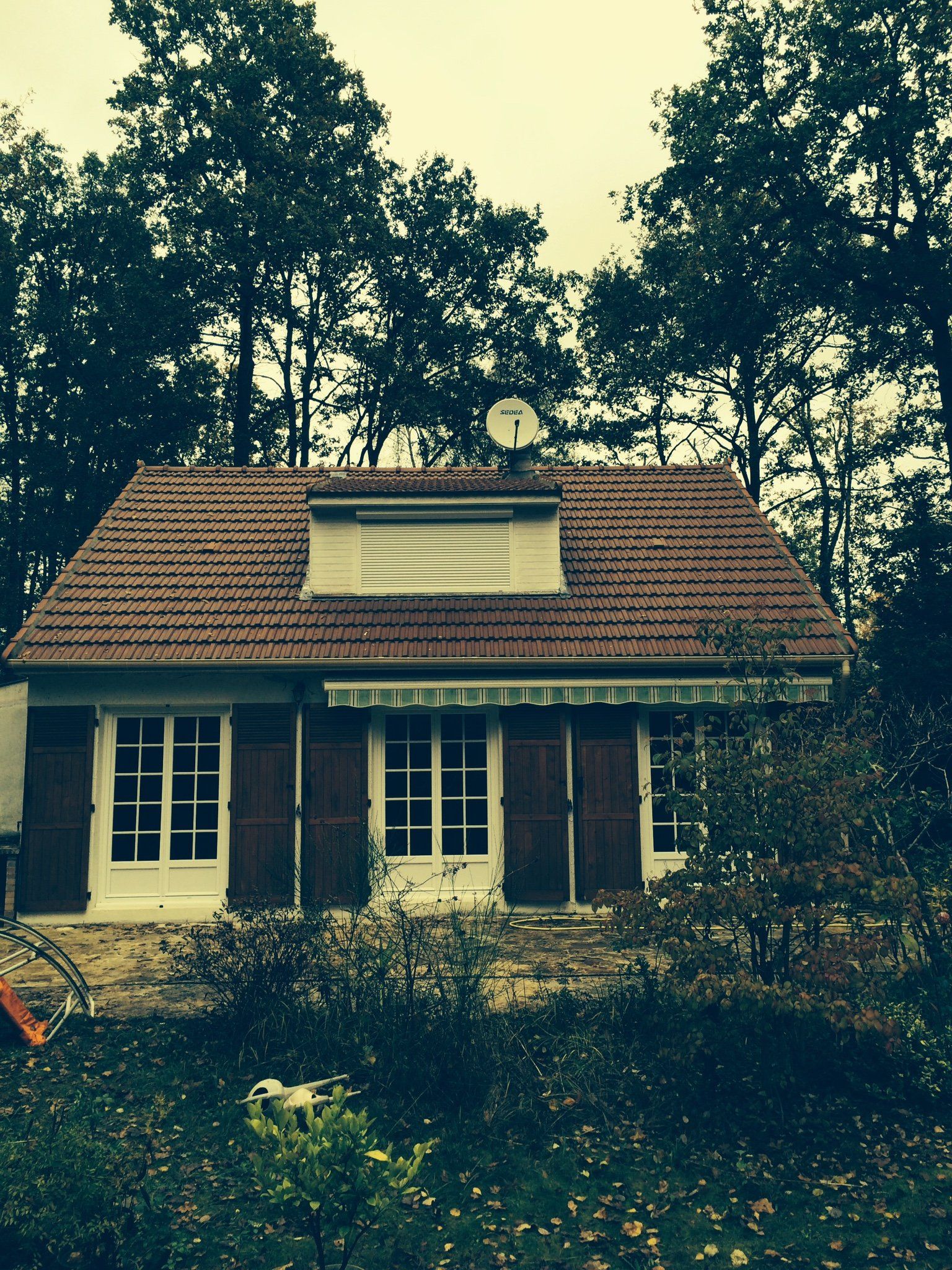 Maison traditionnelle avec toiture terminée après travaux et antenne parabolique