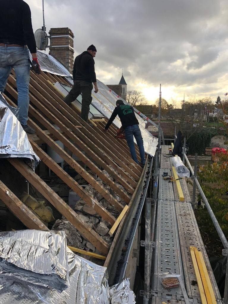 Artisans de PR Couverture travaillant sur une charpente de toit avec échafaudage à proximité