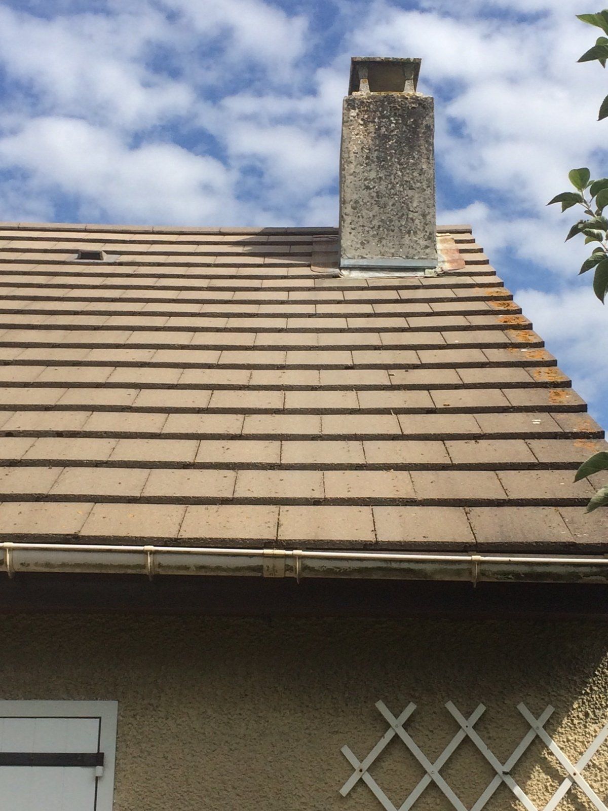 Toit marqué par le temps et la pollution avec une cheminée