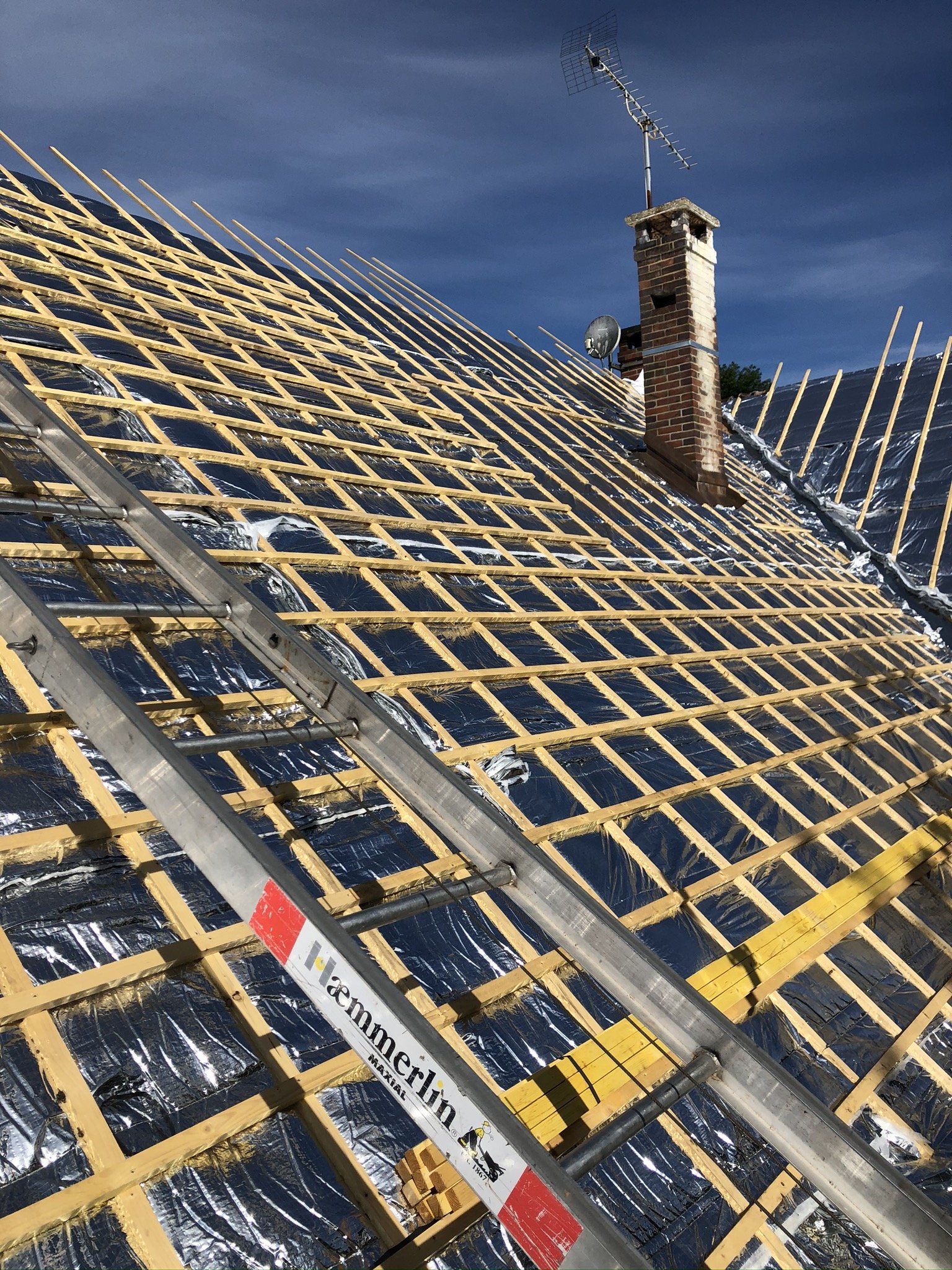 Toit en rénovation avec lattage en bois prêt pour la pose des tuiles