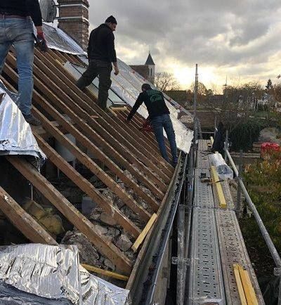 Artisans de PR Couverture travaillant sur une charpente de toit en rénovation sur échafaudage