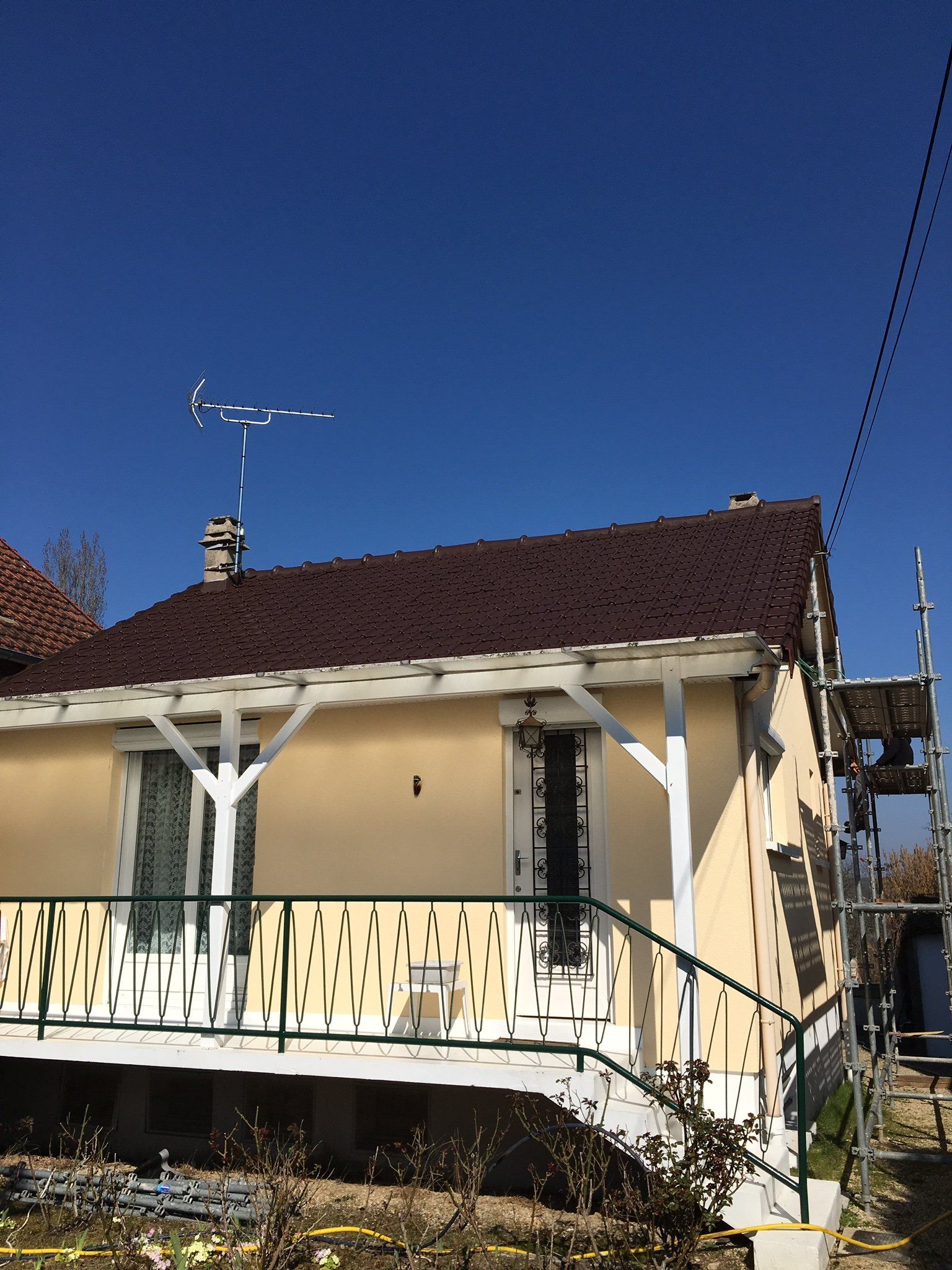 Maison traditionnelle avec toit en tuiles rouges et comportant une antenne