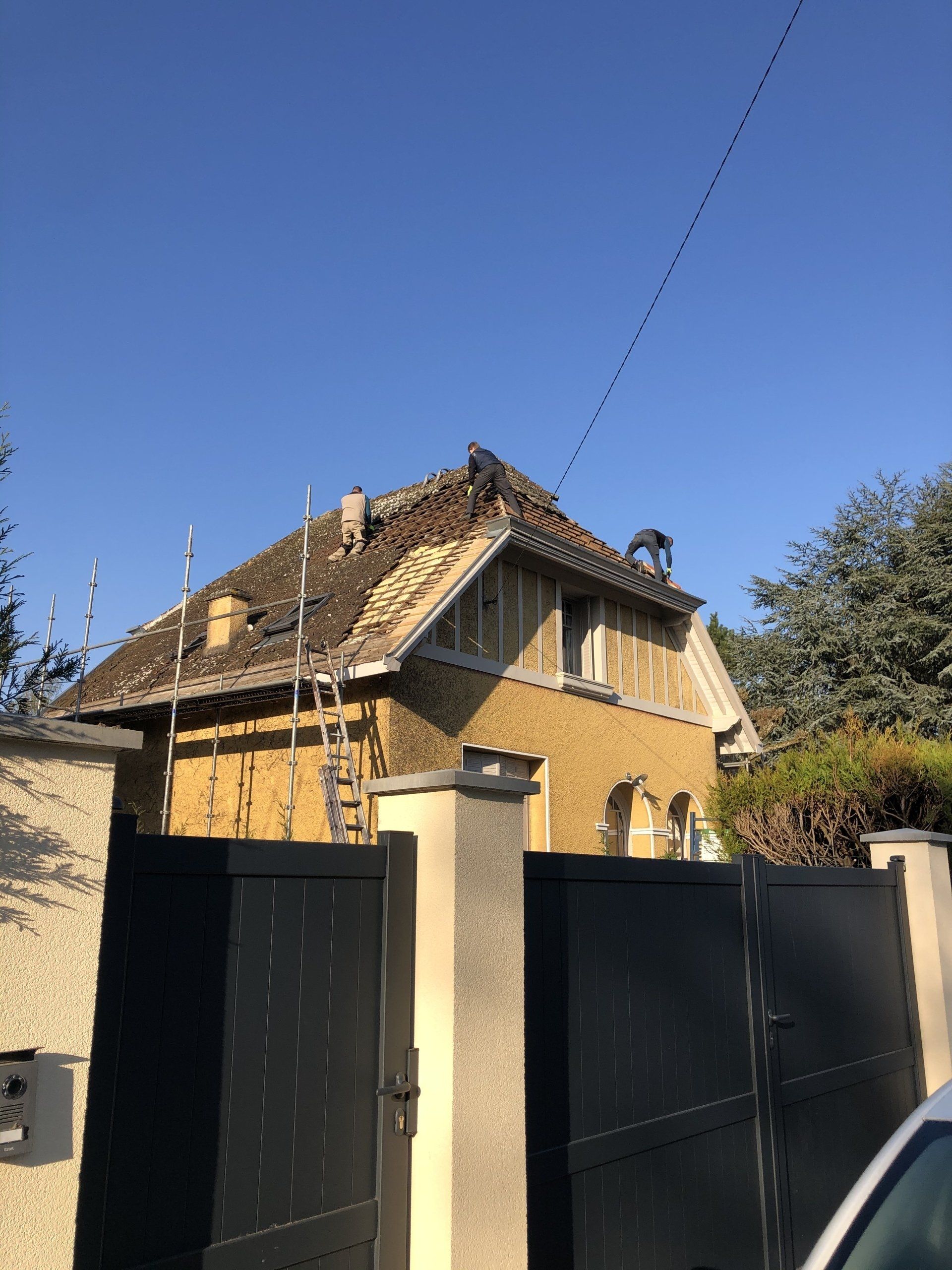 Maison ancienne avec toit en tuile et échafaudage autour pour rénovation