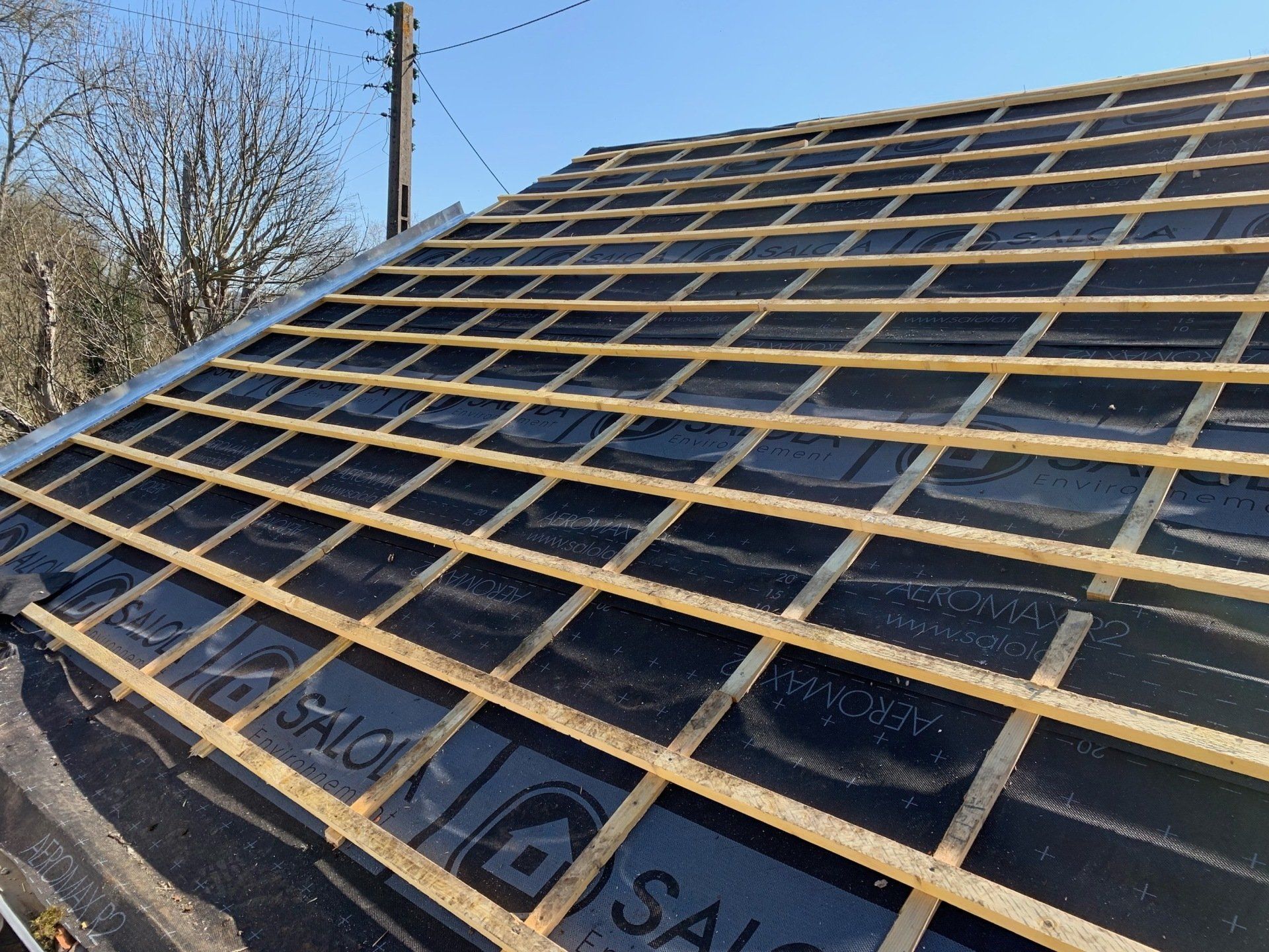 Toit en rénovation avec lattage en bois sur l'ensemble de la surface