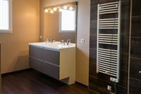 Ein Badezimmer mit zwei Waschbecken, einem Handtuchhalter und einem Spiegel.