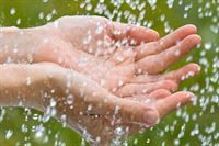 Eine Person hält Wasser in ihren Händen.