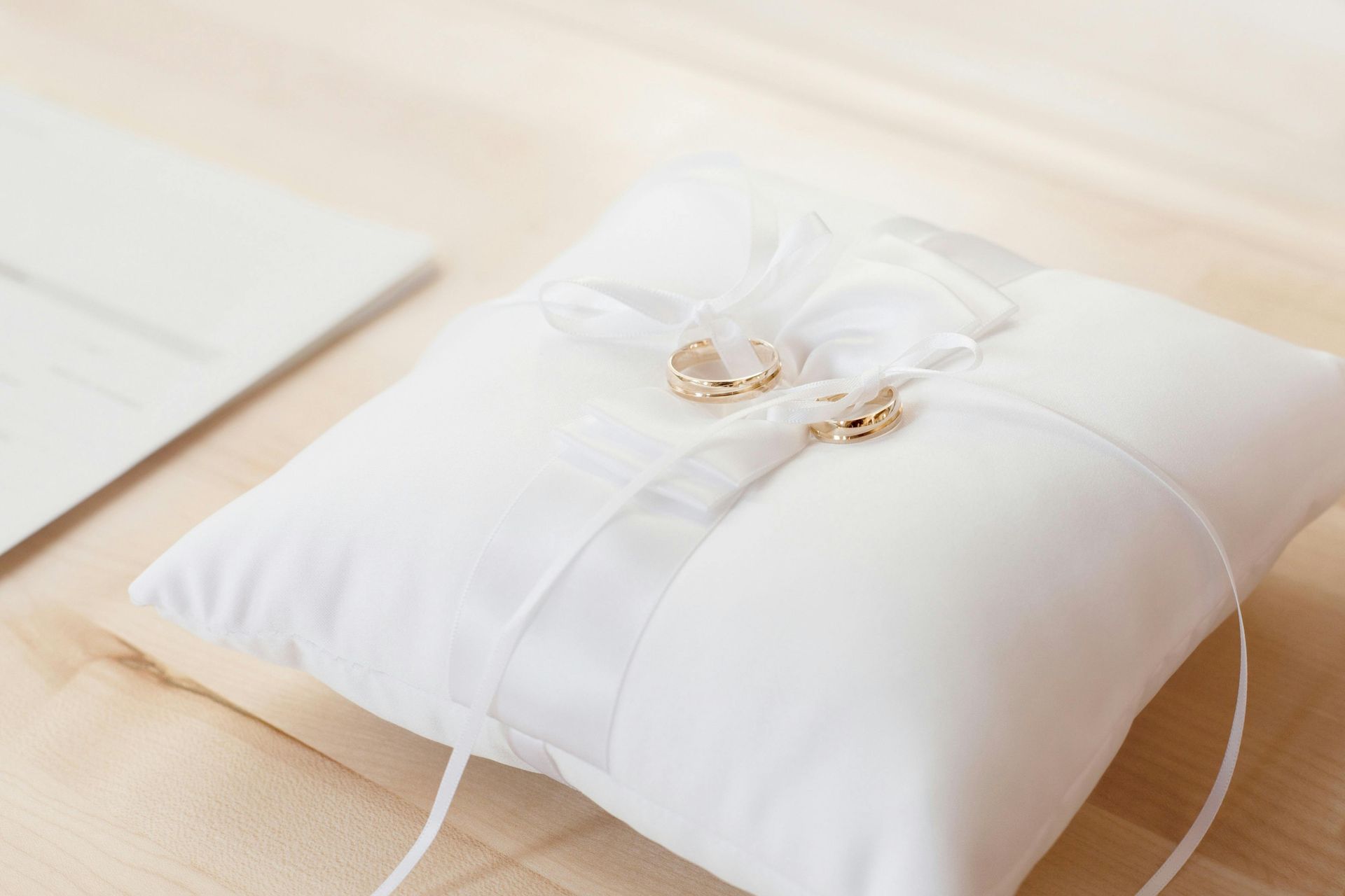 Una almohada blanca con dos anillos de boda encima.