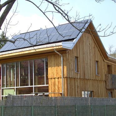 Ein Holzhaus mit Solarzellen auf dem Dach