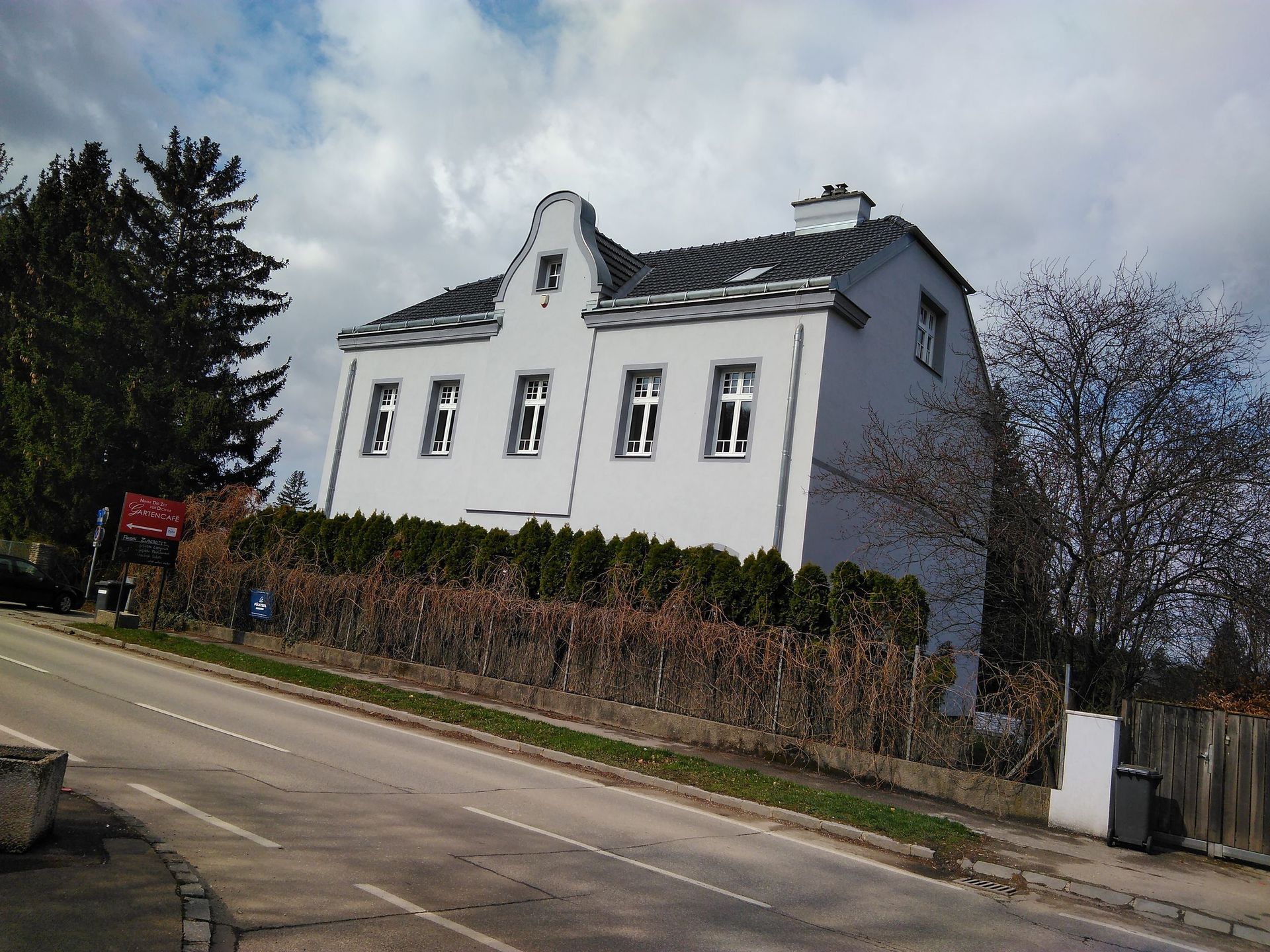 Ein großes weißes Haus steht am Straßenrand