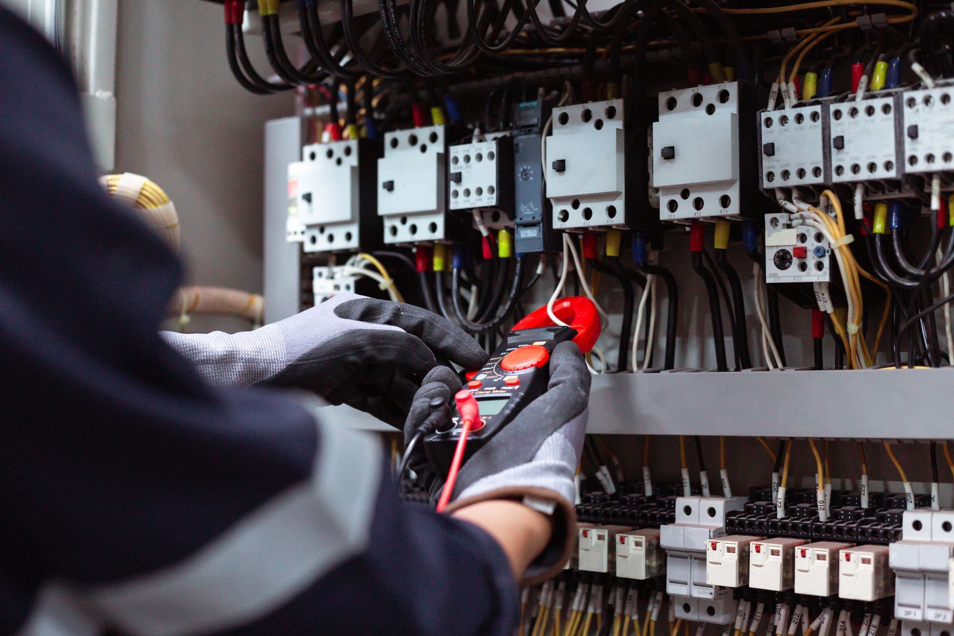 Techniker prüft elektrische Schalttafeln mit einem Multimeter in einem Verteilerschrank