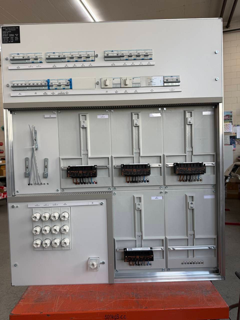 Elektrischer Schaltschrank mit Schaltern, Verkabelung und Schaltungskomponenten in einer Werkstattumgebung