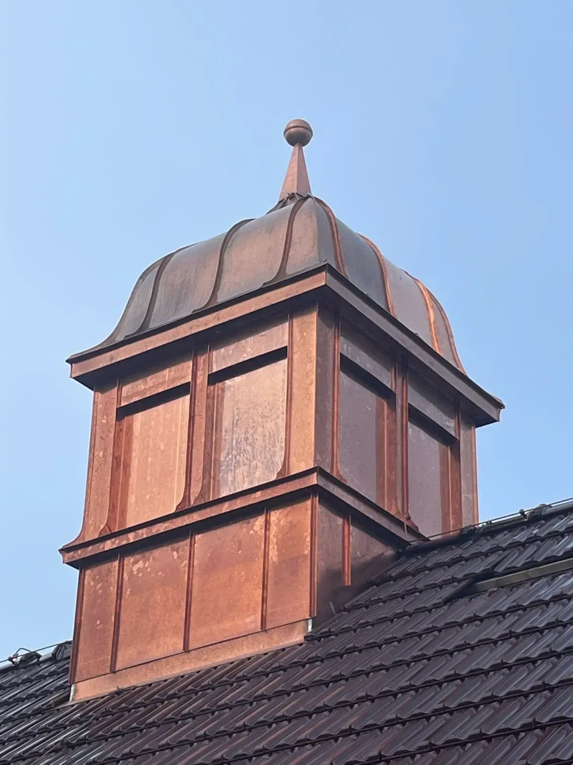 Ein Kupferkamin auf einem Ziegeldach