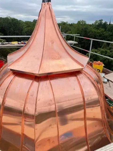 Auf einem Gebäude wird eine Kupferkuppel errichtet