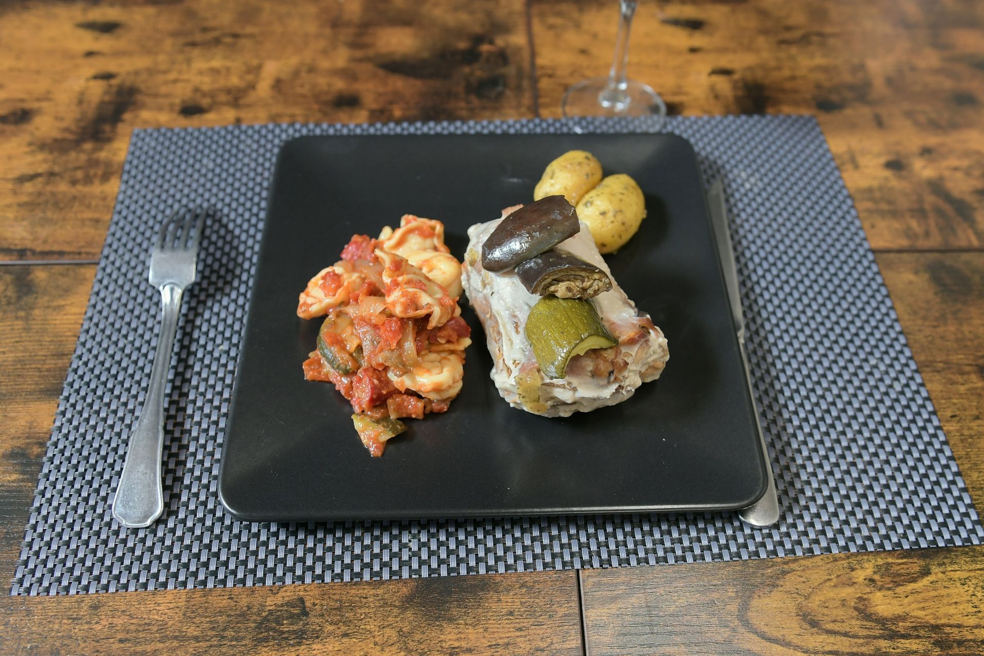 Assiette carrée noire avec plat original aux légumes