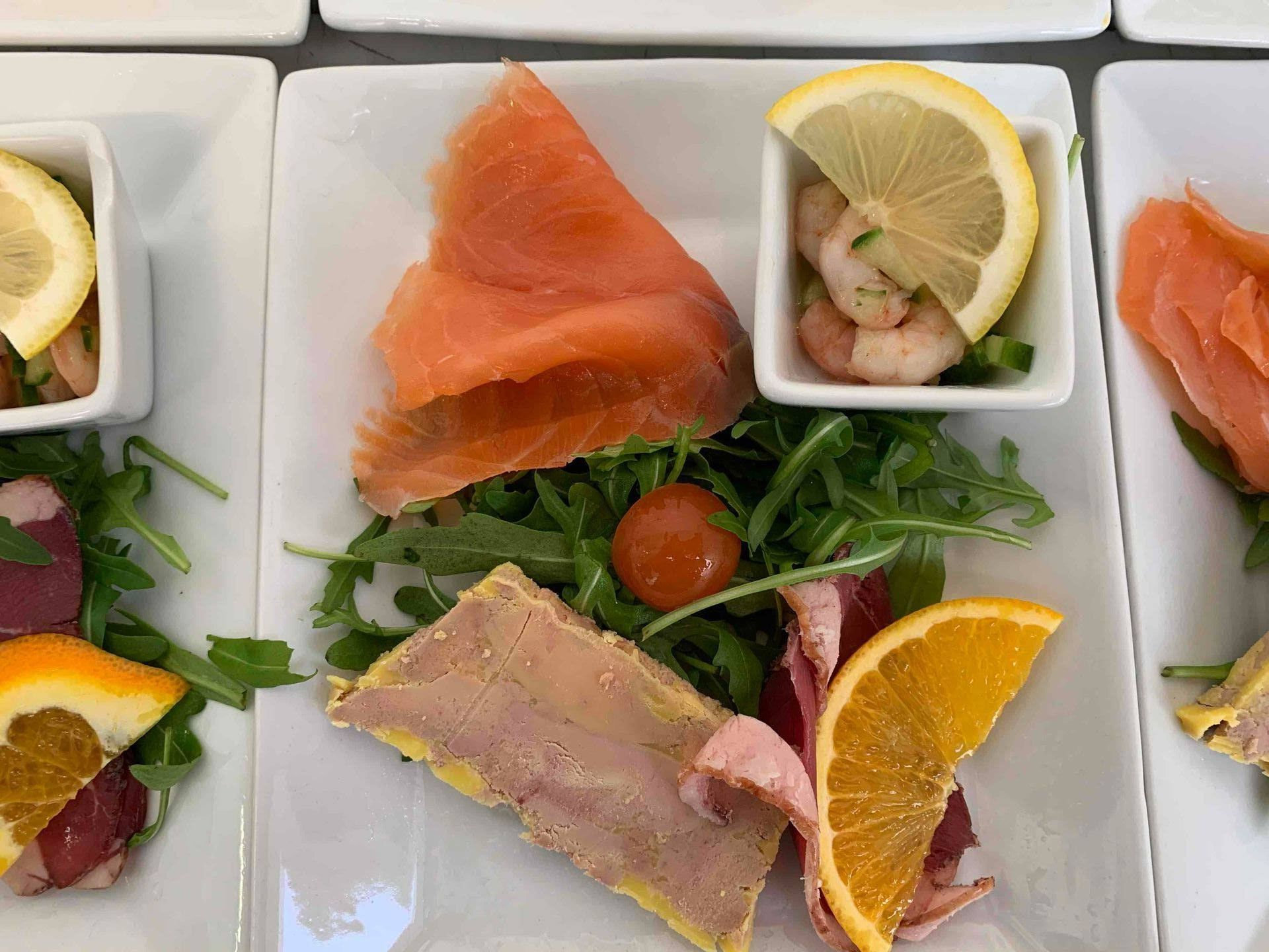 Vue sur des plats de saumon, crevettes et foie gras