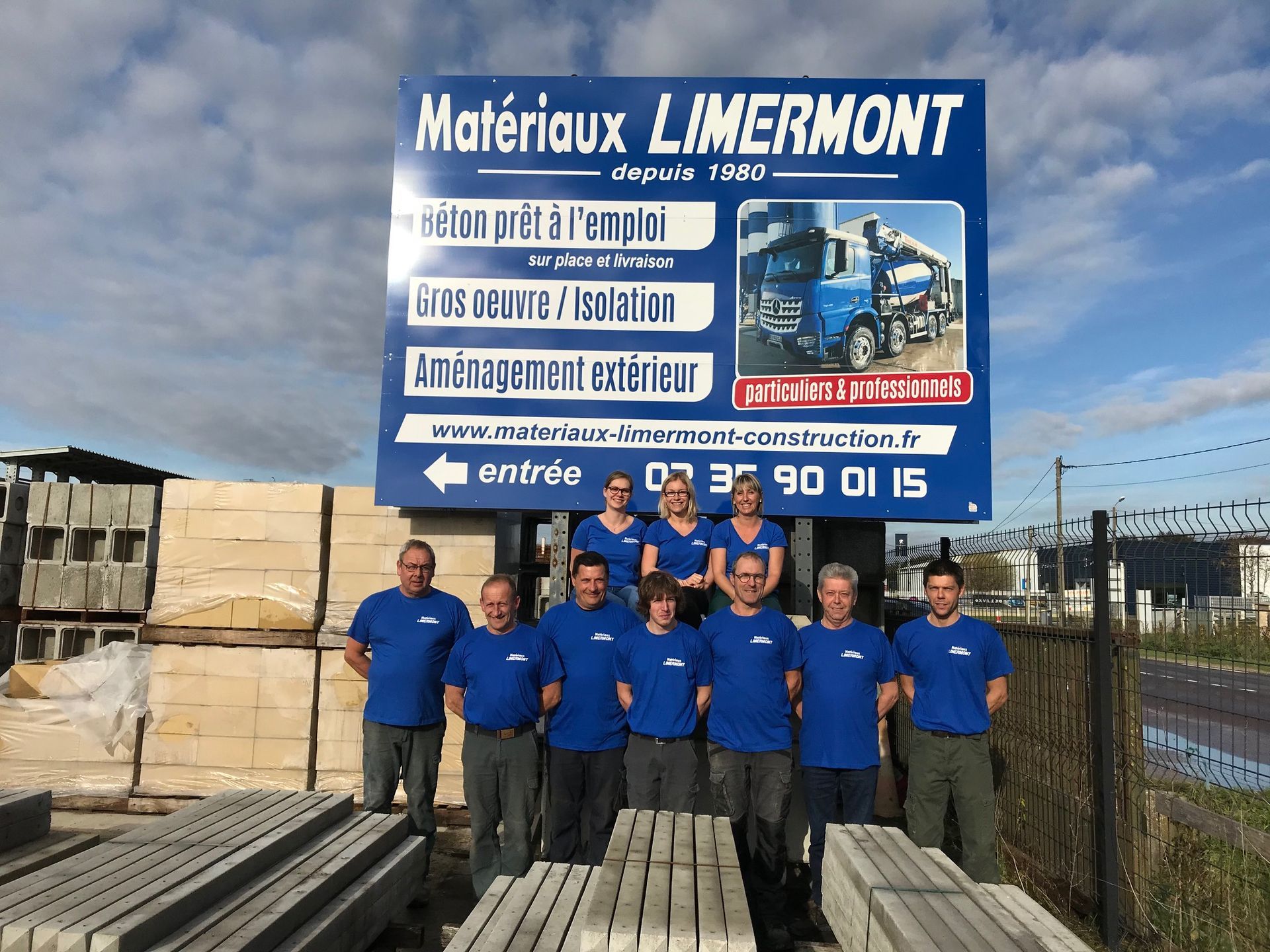 Tous les employés de l'entreprise devant le panneau de l'entrée