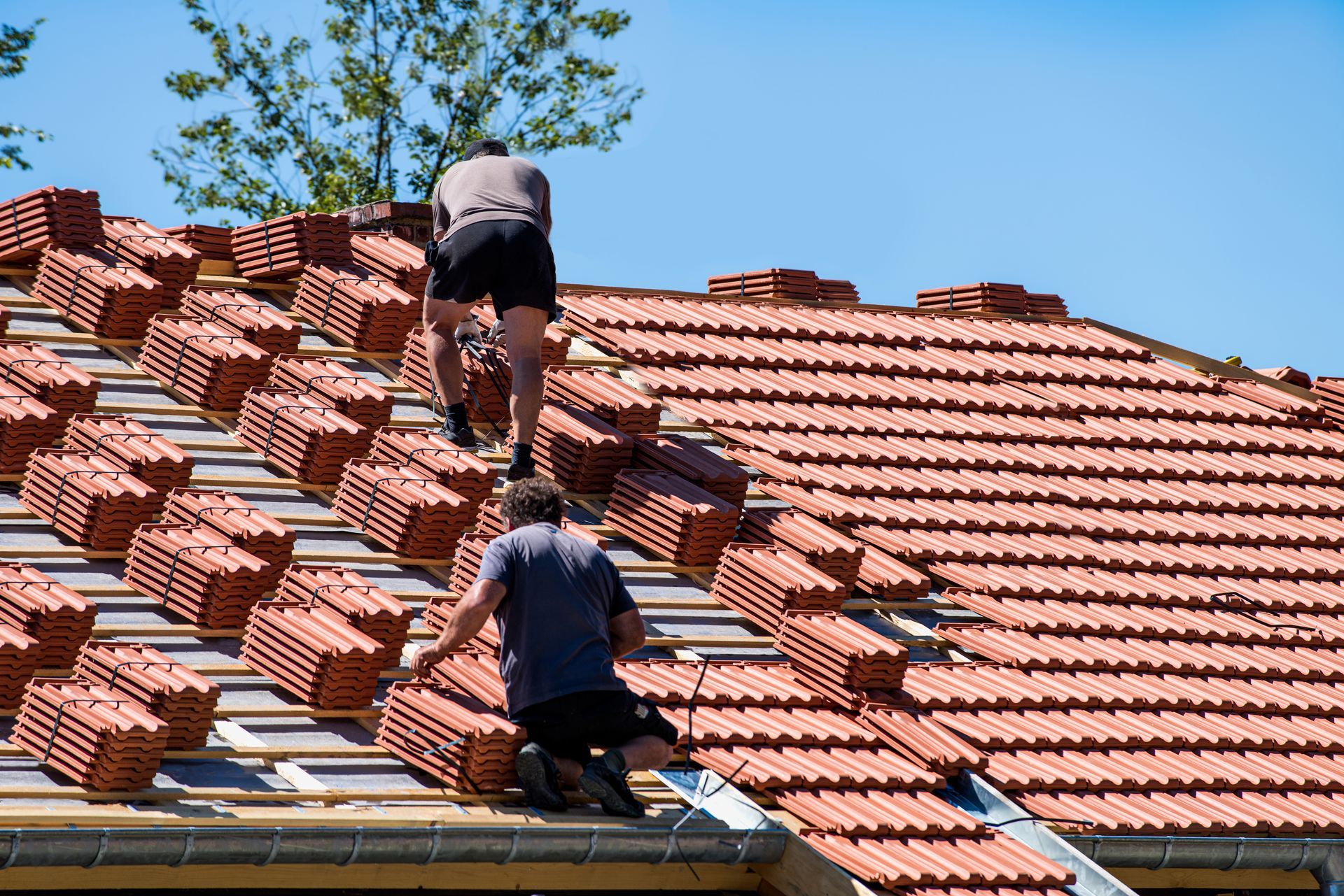 Deux artisans sur un toit en tuiles
