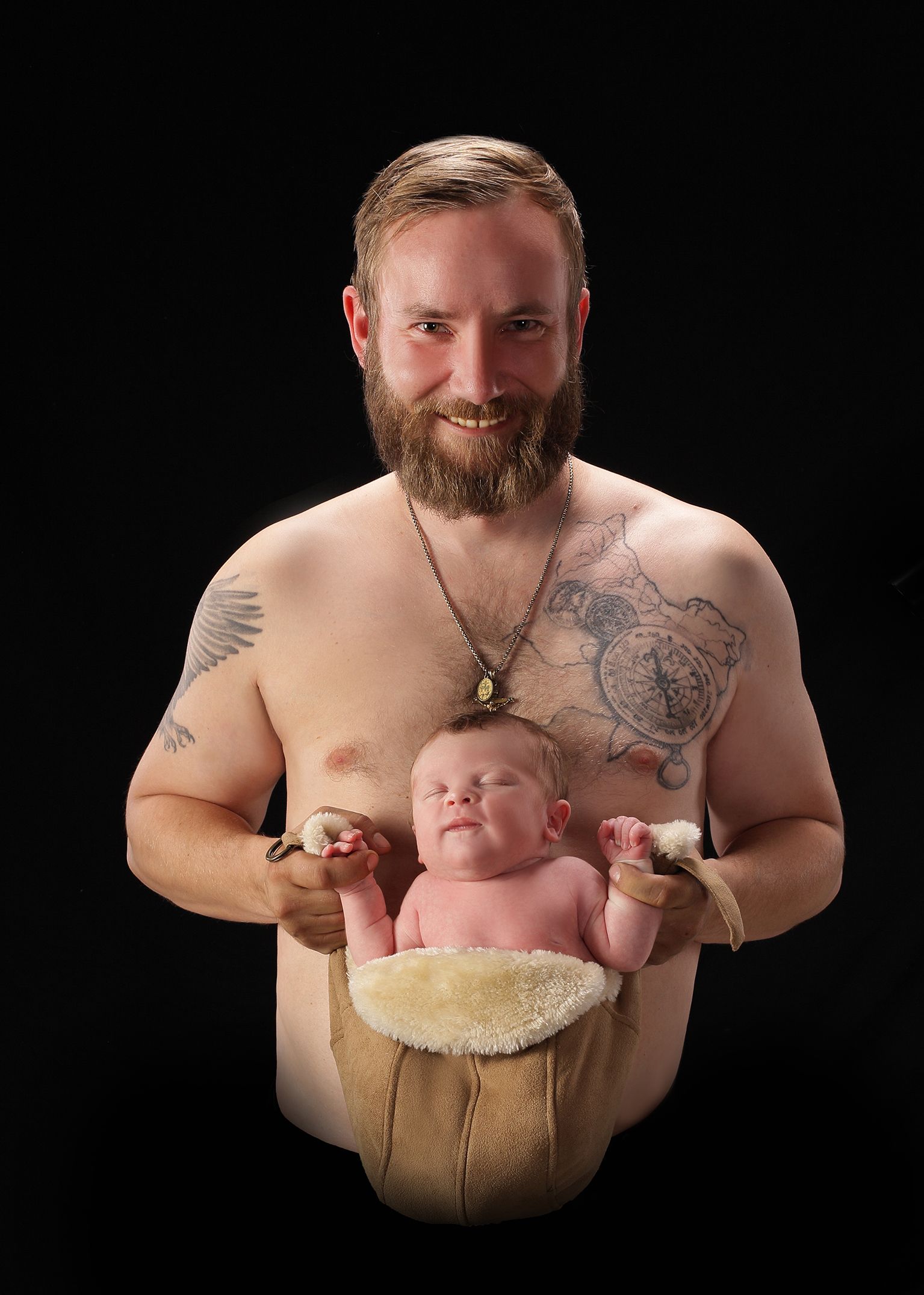 Porträt eines bärtigen Mannes mit freiem Oberkörper im dunklen Studio.