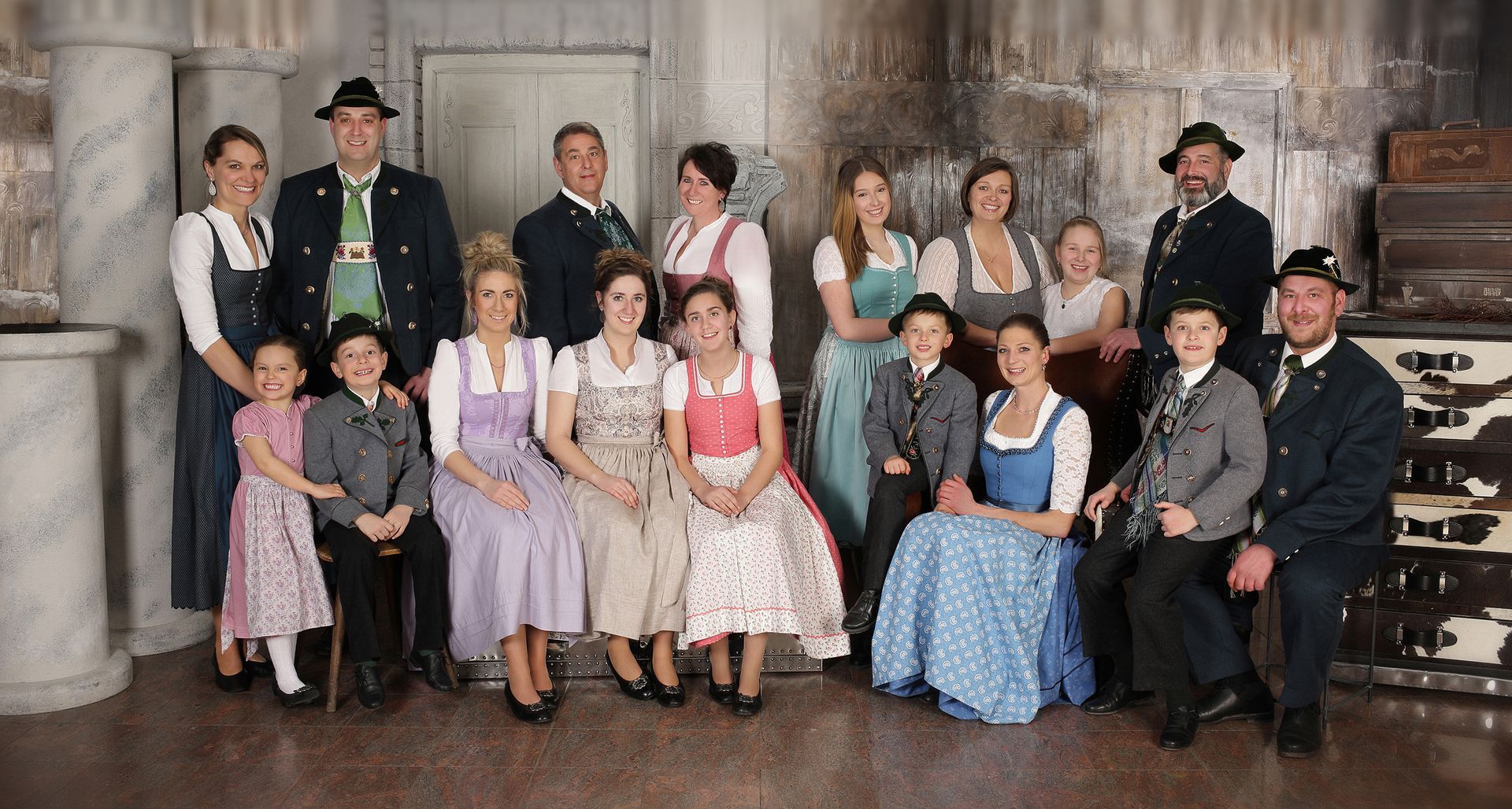 Große Gruppe in traditioneller Tracht posiert gemeinsam im Studio.