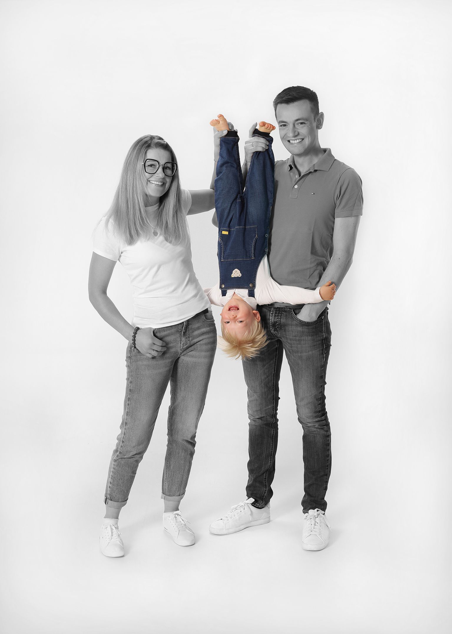 Schwarz-weiß-Aufnahme eines Paares, das gemeinsam eine Kinderhose hält.