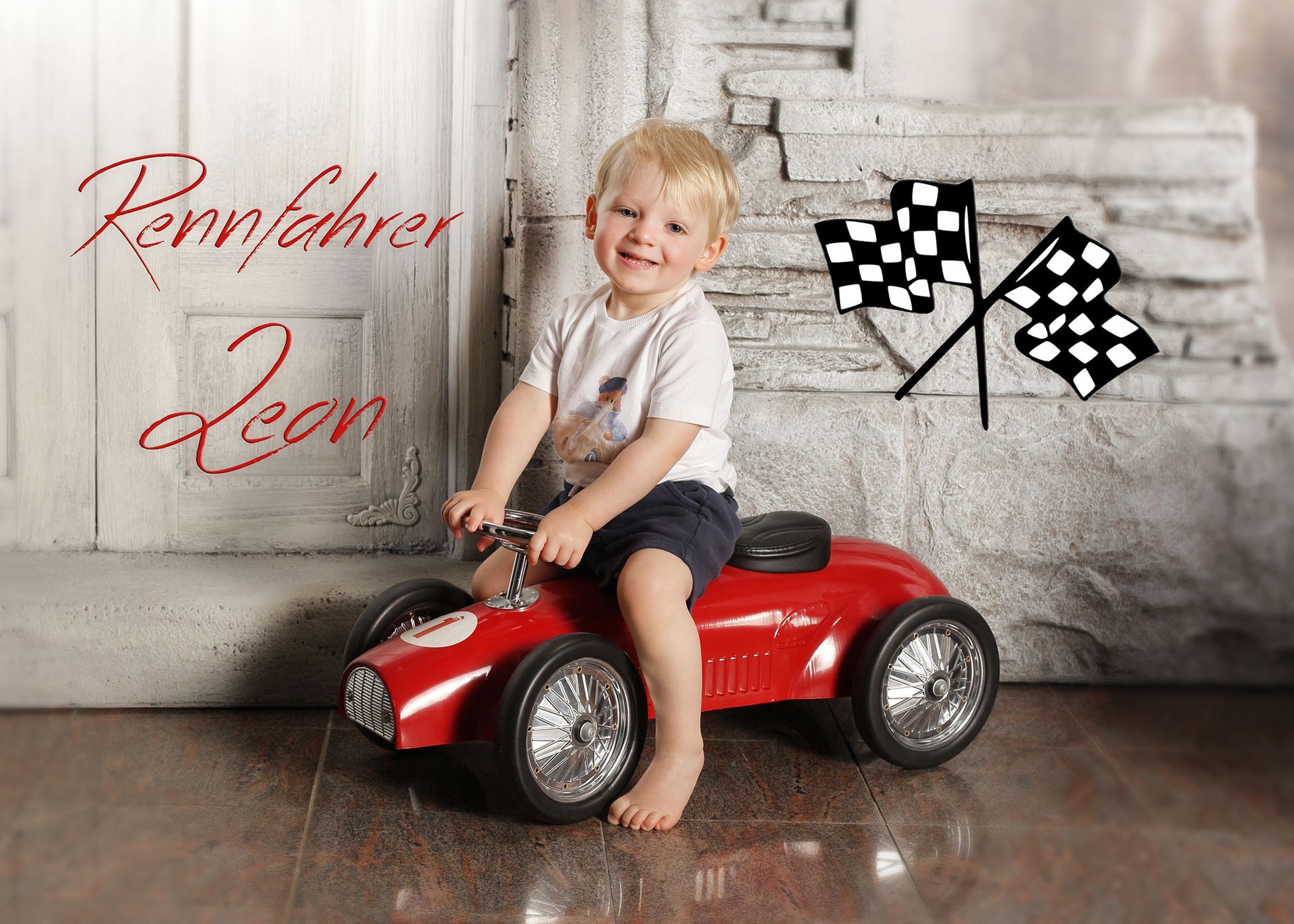 Kleiner Junge sitzt auf einem roten Spielauto vor Rennflaggen.