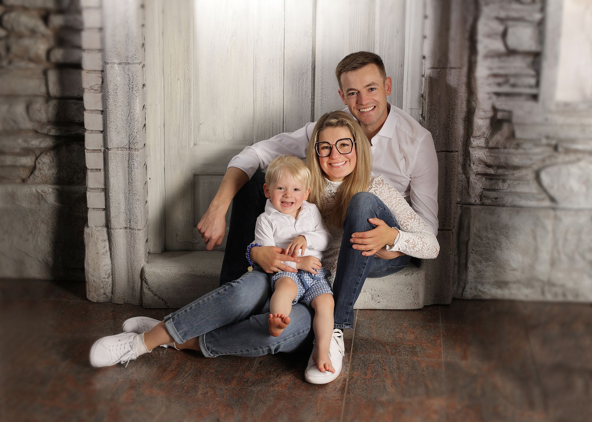 Familienporträt mit Eltern und zwei Kindern vor hellem Studiobackground.