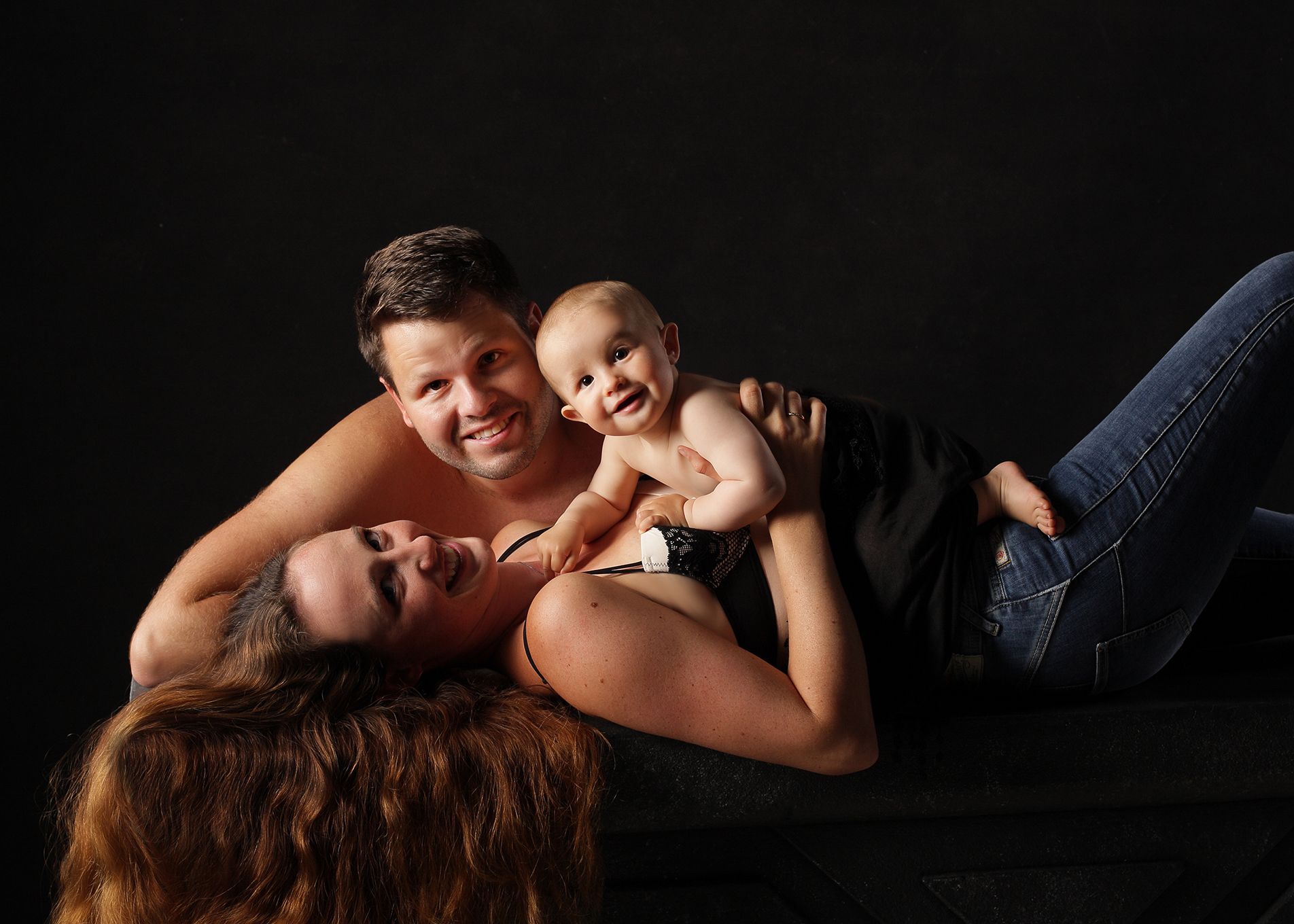 Familie liegend mit ihrem Baby