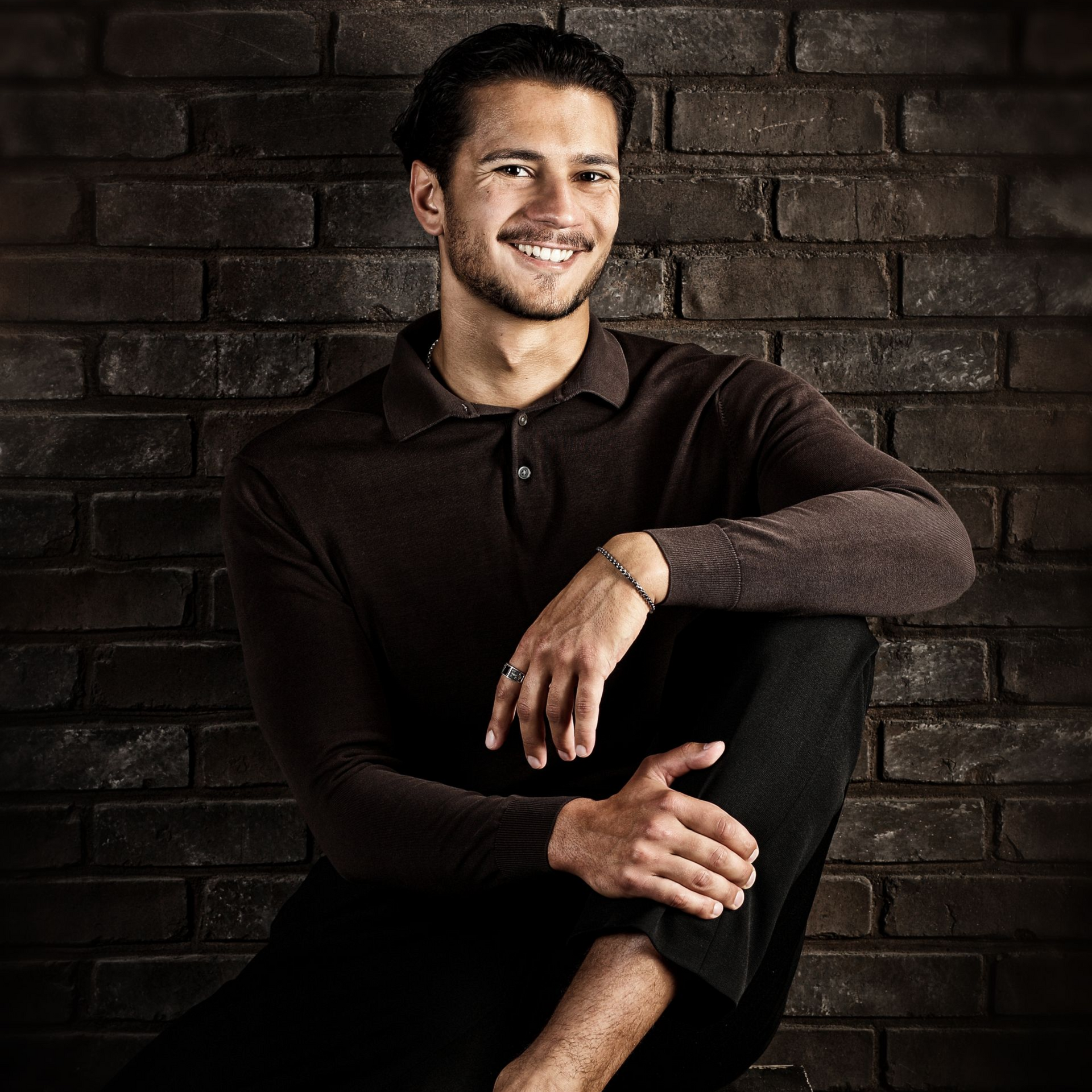 Mann posiert im Sitzen