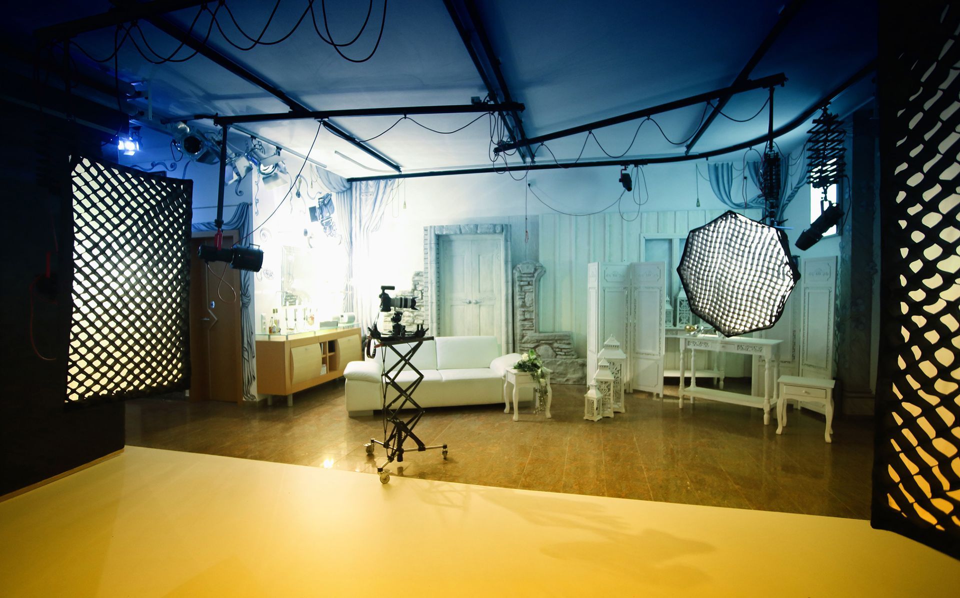 Innenaufnahme eines Fotostudios mit Beleuchtung und Möbeln.