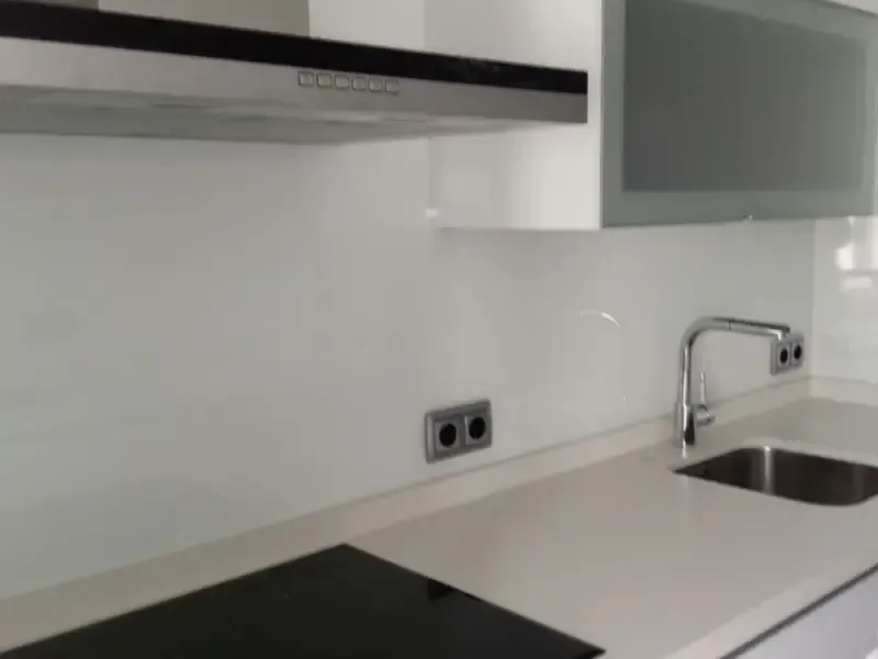 Encimera de cocina moderna con protector contra salpicaduras blanco, fregadero integrado y grifo de acero inoxidable