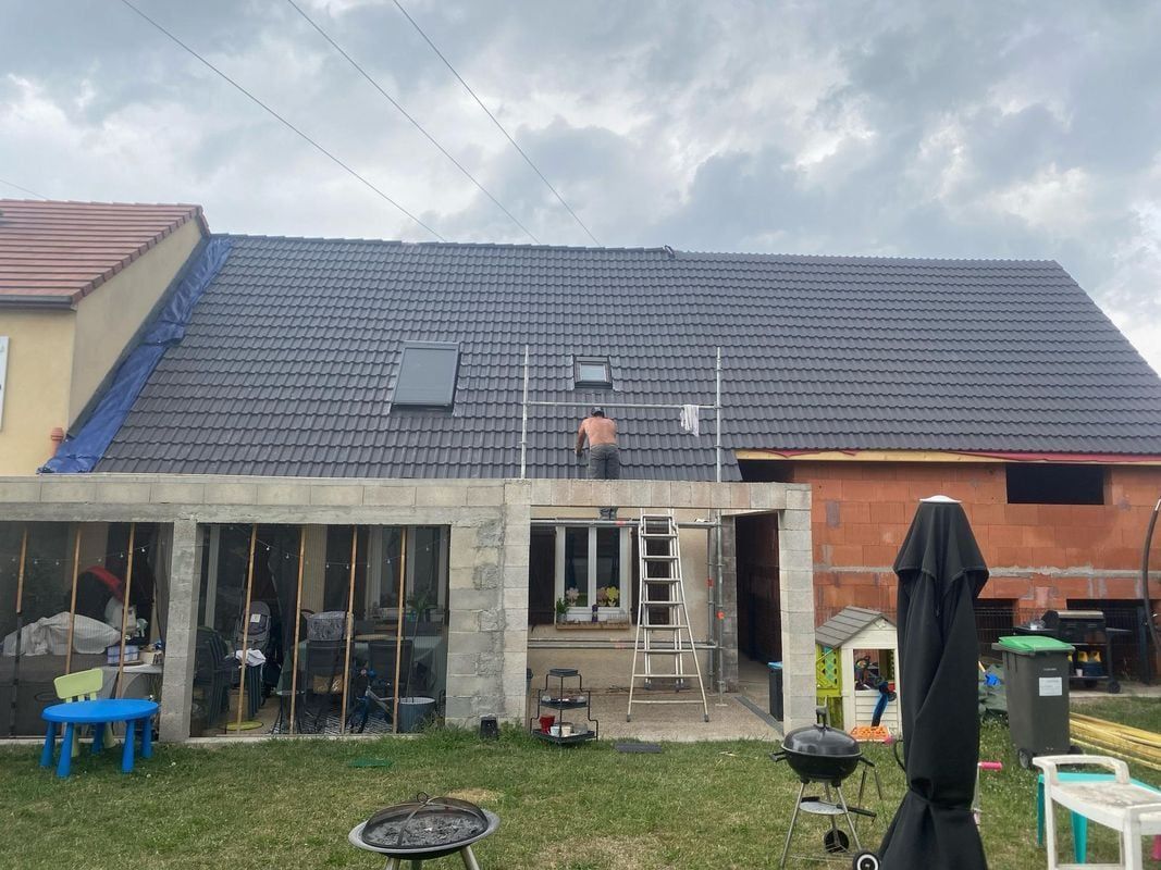 Une personne travaille sur un toit avec un échafaudage.