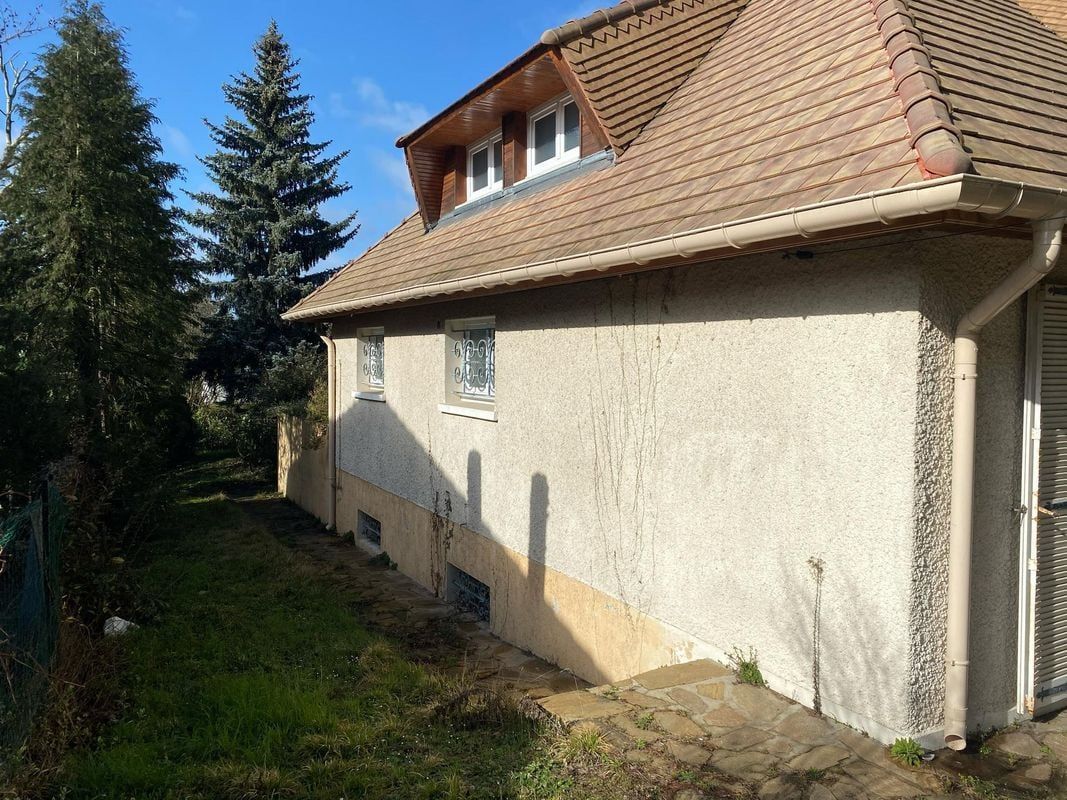 Une maison avec une lucarne, vue de côté.