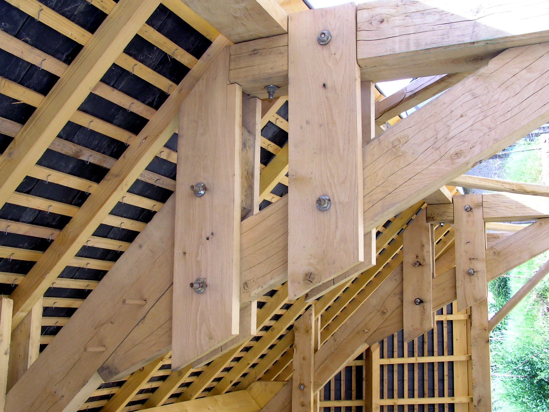 Gros plan sur une charpente en bois avec des poutres.