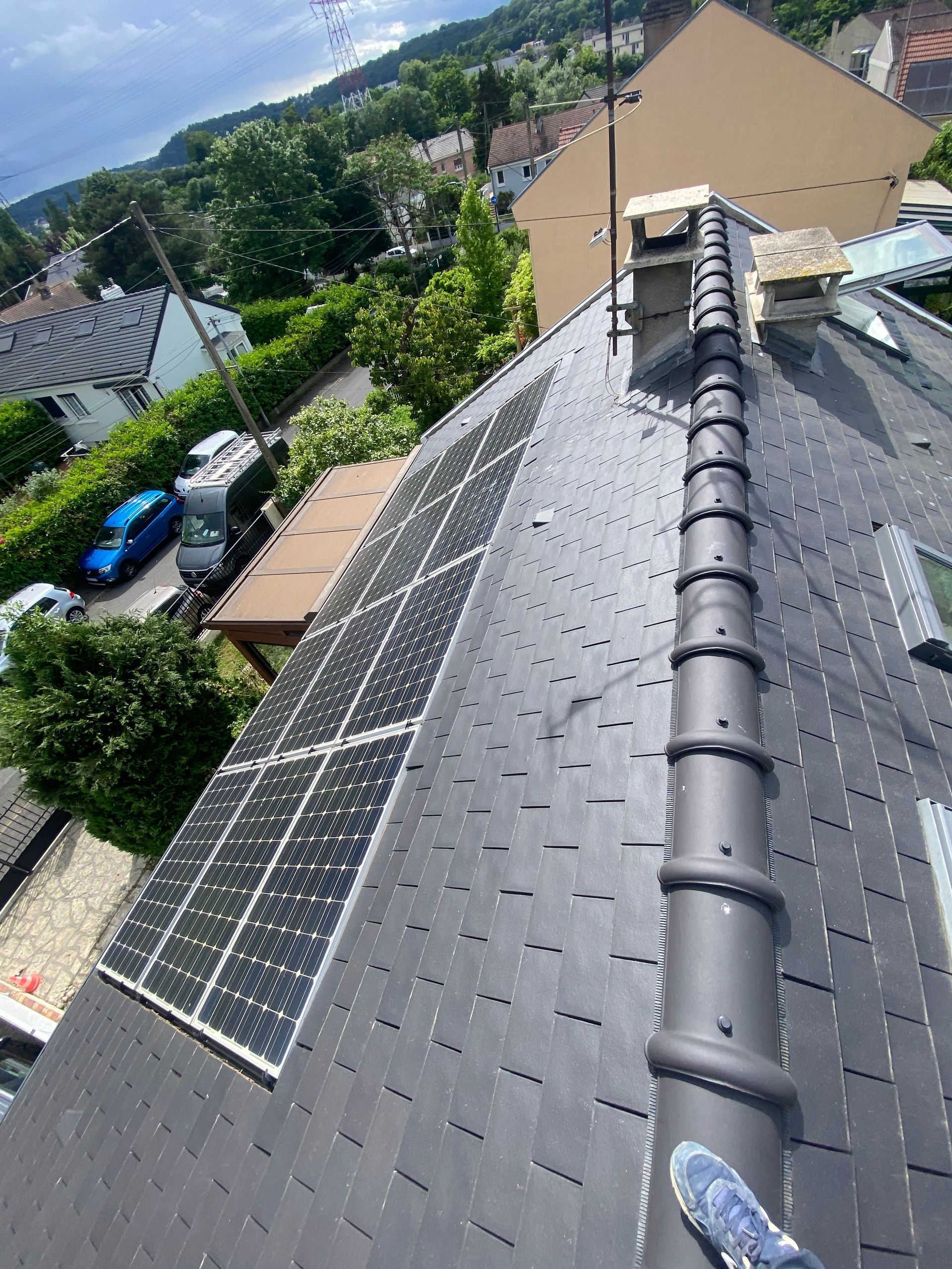 Vue en plongée d'un toit en tuiles avec des panneaux solaires.