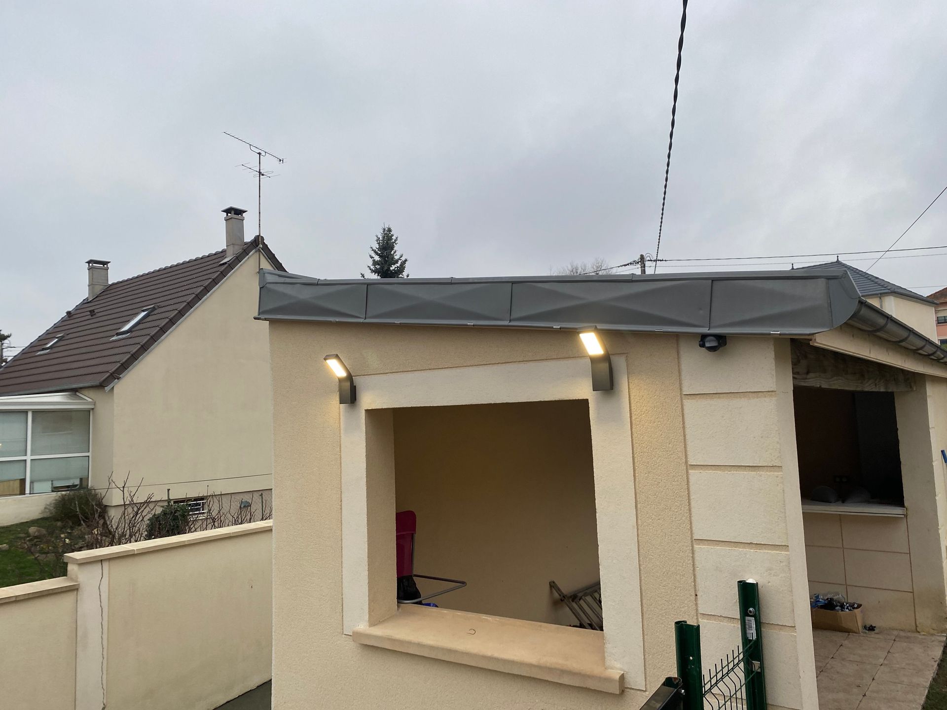 Un abri maçonné avec deux appliques murales éclairées.