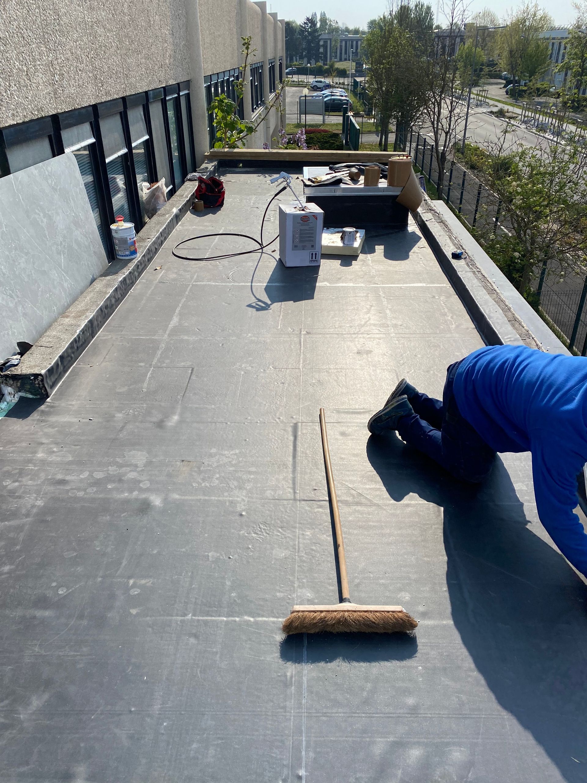 Un couvreur réalise l'étanchéité d'un toit plat.