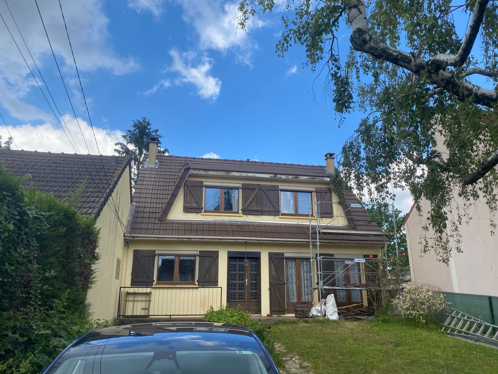 Une maison en rénovation avec des volets en bois.