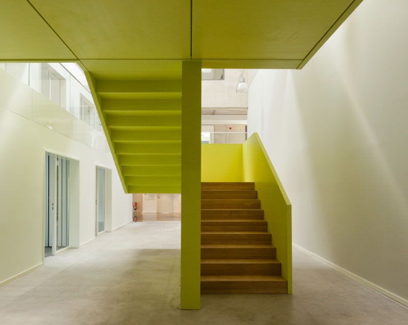 Eine Treppe in einem Gebäude mit einem grünen Geländer