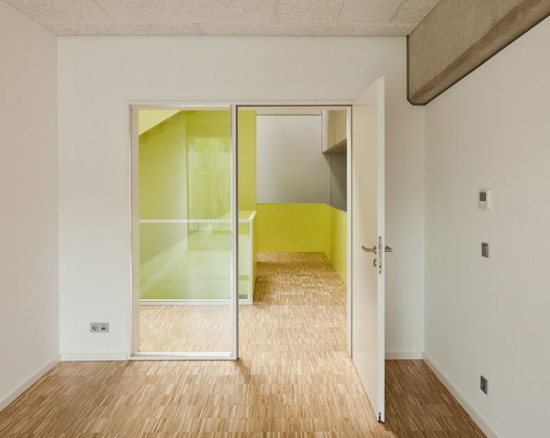 Ein leerer Raum mit einer offenen Tür und einer gelben Wand