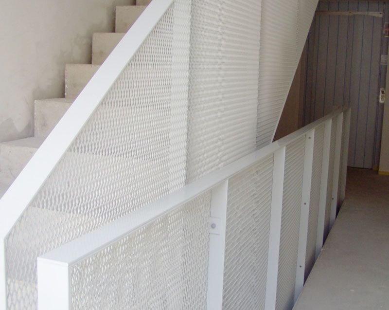 Eine weiße Treppe mit einem weißen Geländer in einem Flur